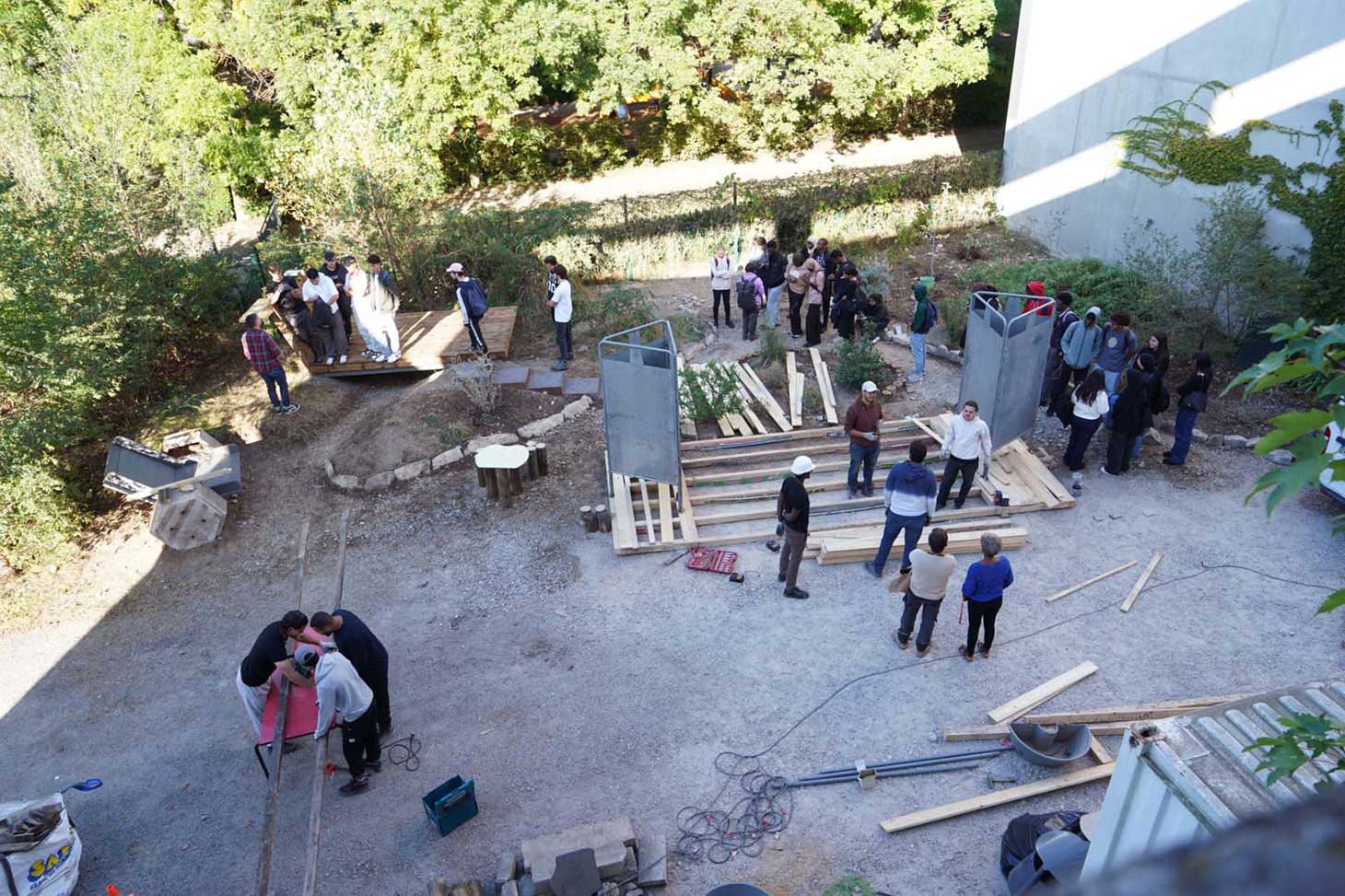 Des étudiantes et étudiants issus des filières génie civil et architecture bâtissent un espace convivial et fonctionnel dans le jardin de l’Institut d’Urbanisme et de Géographie Alpine uniquement avec des matériaux de réemploi.